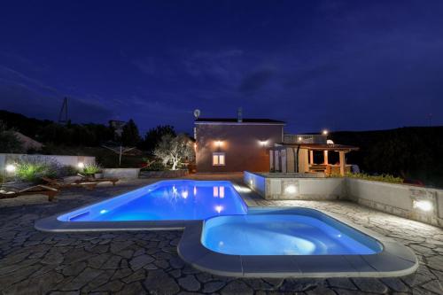 a large blue pool in a yard at night at Villa Bella in Kruševo