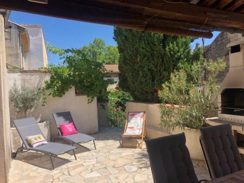 - un ensemble de chaises assises sur une terrasse dans l'établissement Typique maison de village, à Saint-Quentin-la-Poterie