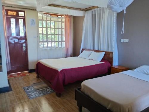 a hotel room with two beds and a window at BIMOSS BEACH RESORT in Mbita