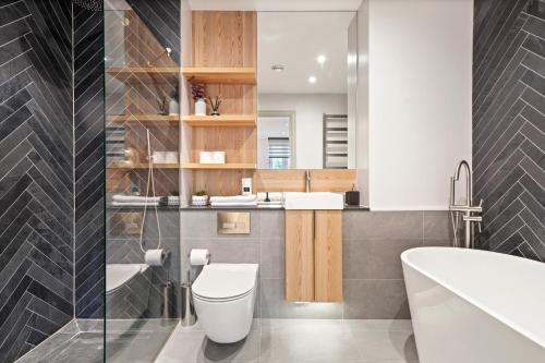 a bathroom with a toilet and a sink at Cosy London Retreat - Sleeps 6 in London