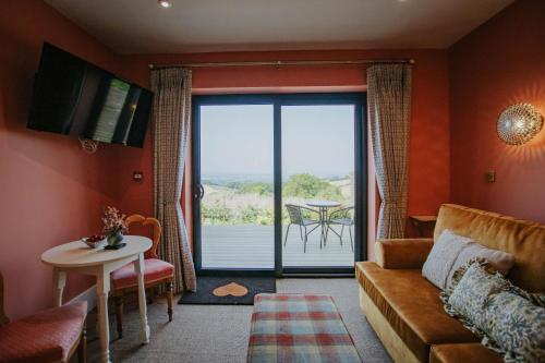 a living room with a couch and a sliding glass door at Hanley House in Tenbury