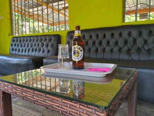 a bottle of beer sitting on a table with a glass at BIMOSS BEACH RESORT in Mbita