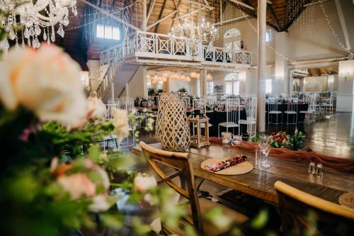 a dining room with a table and chairs with flowers at Siesta Guesthouse & Wedding Venue - Frankfort in Frankfort