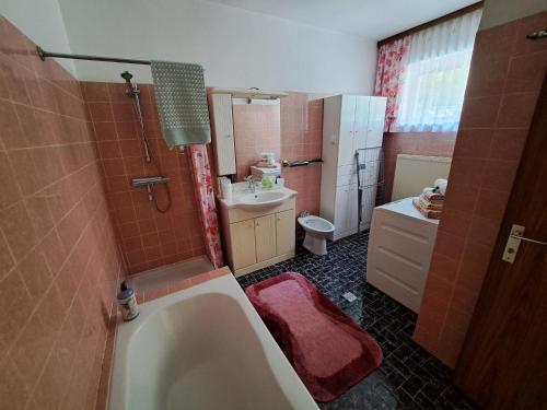 uma casa de banho com uma banheira, um lavatório e um WC. em Appartement Eigelsreiter Lilienfeld em Lilienfeld
