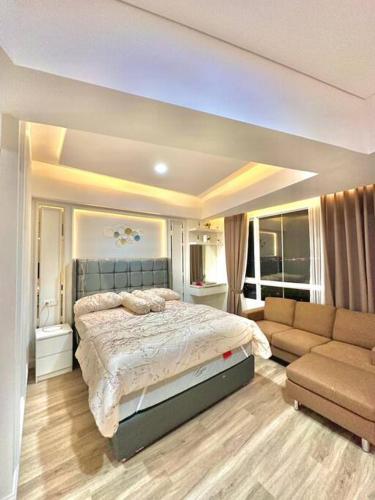 a large bedroom with a bed and a couch at Apartmen Sea View Lampung Mall 