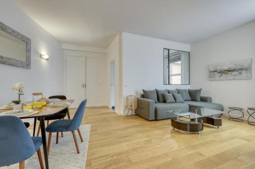un salon avec un canapé et une table dans l'établissement Chic and Warm 1 bd Flat - Heart of the Luxury 16th, à Paris