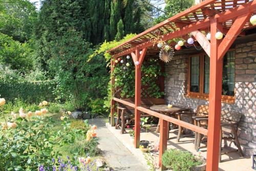 a wooden pergola with a table in a garden at Sunnyside in Bristol