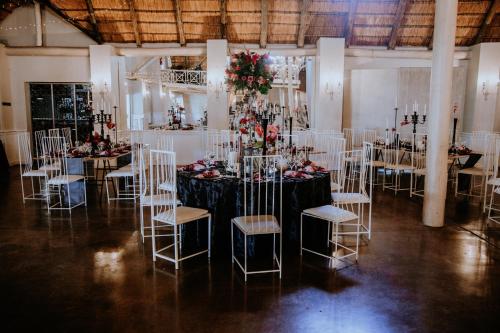 a room with a table with chairs and flowers at Siesta Guesthouse & Wedding Venue - Frankfort in Frankfort