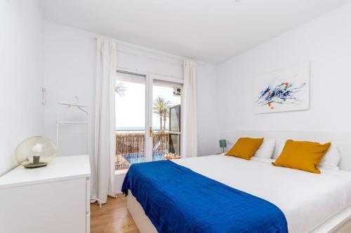 ein weißes Schlafzimmer mit einem großen Bett und einem Fenster in der Unterkunft Canela Homes COSTA CASTELLDEFELS in Castelldefels