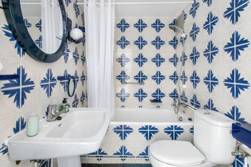 La salle de bains bleue et blanche est pourvue de toilettes et d'un lavabo. dans l'établissement Canela Homes COSTA CASTELLDEFELS, à Castelldefels