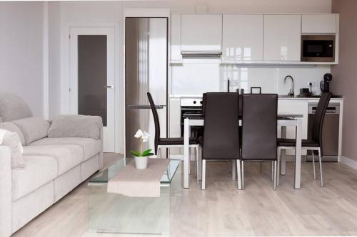 un soggiorno con un divano e un tavolo con sedie di Apartamento primera línea mar Garachico a Garachico
