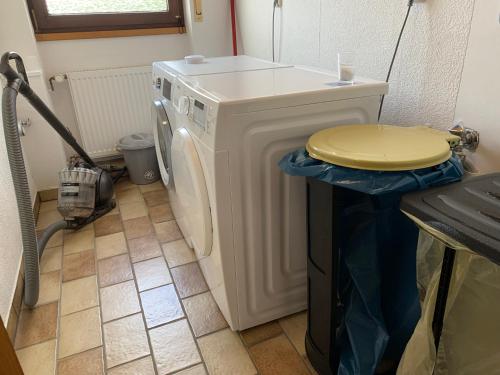 uma máquina de lavar roupa com uma tampa amarela em cima em Wohnen im Herrenwäldchen em Brombachtal