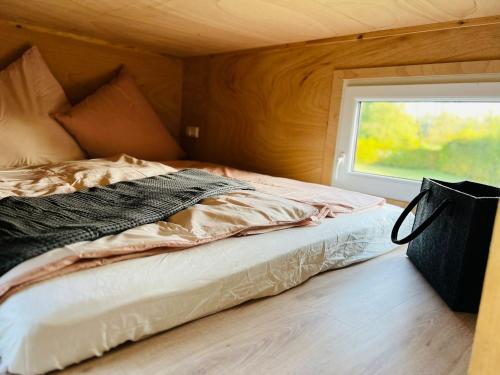 uma cama num pequeno quarto com uma janela em Tiny House Xantener Nordsee em Xanten