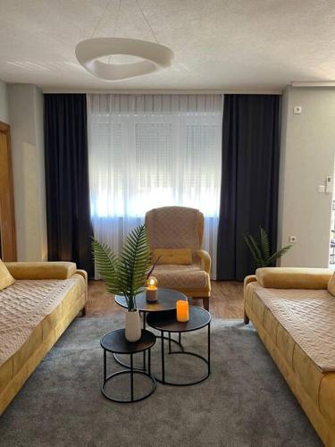 uma sala de estar com dois sofás e uma mesa em Etern Stays - Nook Apartment em Pristina