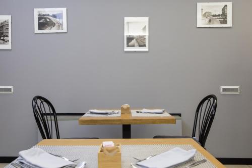 a table and chairs in a room with pictures on the wall at Hotel Berlino in Milan