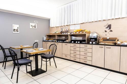a restaurant with a table and chairs in a kitchen at Hotel Berlino in Milan