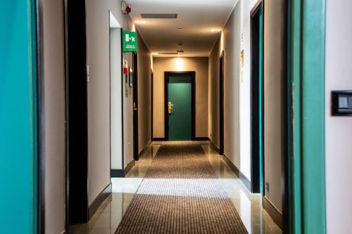 a corridor in a building with a green door at Hotel Berlino in Milan