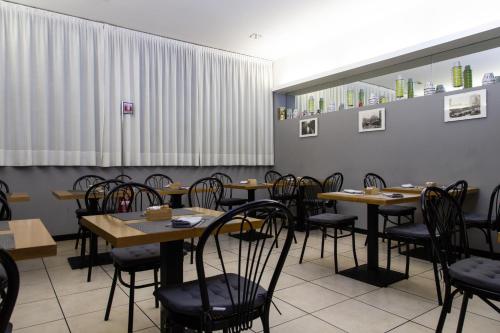 a dining room with wooden tables and chairs at Hotel Berlino in Milan