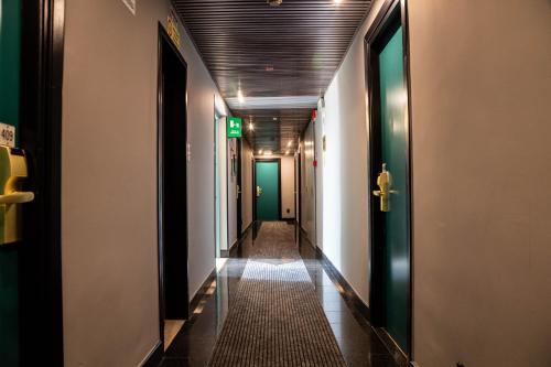 a hallway with a long corridor with green doors at Hotel Berlino in Milan