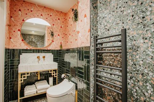 a bathroom with a sink and a toilet and a mirror at Hanley House in Tenbury