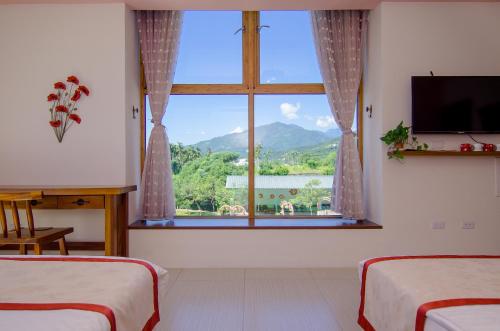 a room with two beds and a large window at XinFu Traveler Inn in Taiping