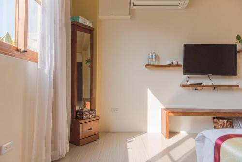 a living room with a television and a bed at XinFu Traveler Inn in Taiping