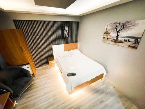 ein Schlafzimmer mit einem weißen Bett und einem Sofa in der Unterkunft DNC REZİDANCE in Konak