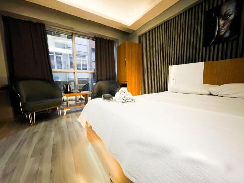 ein Schlafzimmer mit einem großen weißen Bett und einem Fenster in der Unterkunft DNC REZİDANCE in Konak