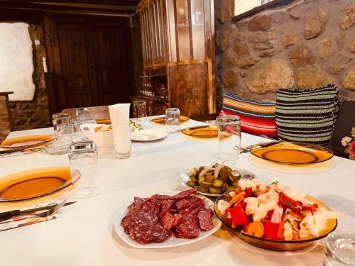 a white table with plates of food on it at Guest House “Anchetata” in Apriltsi