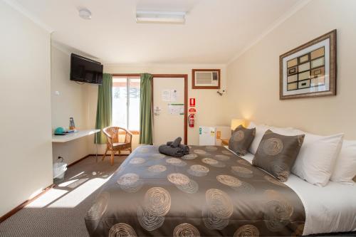 a bedroom with a large bed in a room at Ardrossan Hotel Motel in Ardrossan