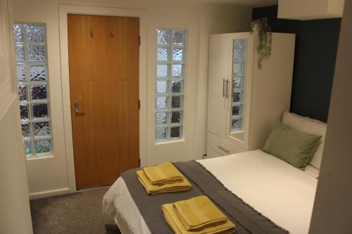 里茲的住宿－Flat 1, Allerton House，一间卧室配有一张床,上面有两条毛巾