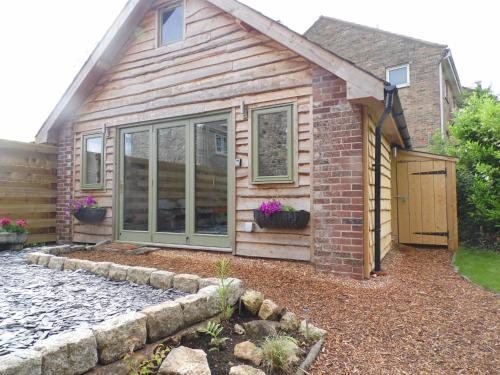 a brick house with a door and a yard at Newchurch Nook in Newchurch