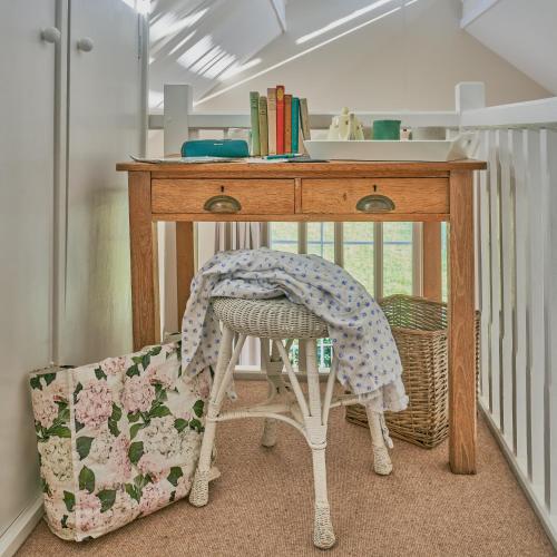 a desk with a chair under a table at The Pump House At Wiston Estate in Ashington