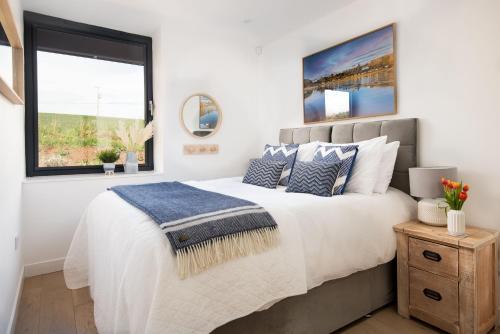 Un dormitorio con una cama grande y una ventana en 6 The Bay en Coldingham