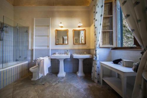 a bathroom with two sinks and a tub and a toilet at Villa de' Ricci Rignana B&B in Greve in Chianti