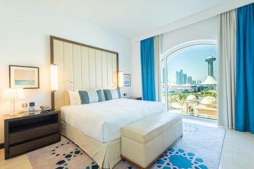 ein Schlafzimmer mit einem großen Bett und einem großen Fenster in der Unterkunft Voyage One Bedroom In Fairmont in Abu Dhabi