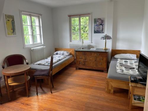 a bedroom with two beds and a desk and a table at Studio Apartment Villa Seiz in Schwäbisch Gmünd