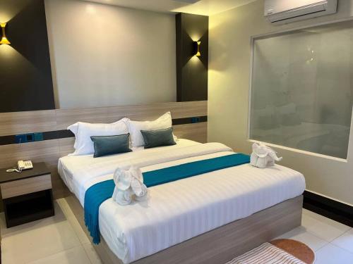 a bedroom with a large bed with towels on it at Twin Hotel Kampot in Kampot