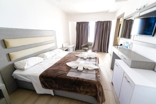 a bedroom with a bed and a table with towels at Captain Pier Hotel in Protaras