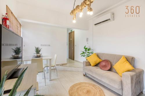 - un salon avec un canapé et une table dans l'établissement Charming 1BR APT with access to roof top terrace by 360 Estates, à San Ġiljan