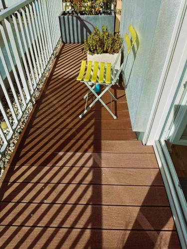 a balcony with a yellow chair and a plant at Sylvis Home Zentral gelegenes Ferienhaus in ruhiger Lage in Fürth