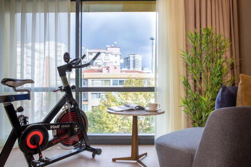 sala de estar con bicicleta estática frente a una ventana en Broyt Hotel, en Estambul