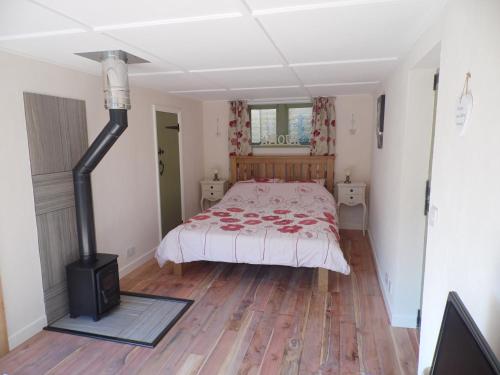 a bedroom with a bed and a woodburning stove at Newchurch Nook in Newchurch