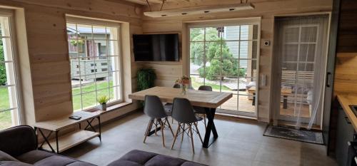 a living room with a wooden table and chairs at Kopa Jura apartment on the beach in Palanga