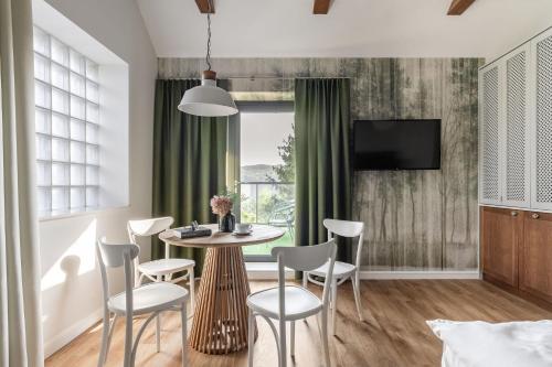 a dining room with a table and chairs and a television at Tawerna Kaszubska in Ostrzyce