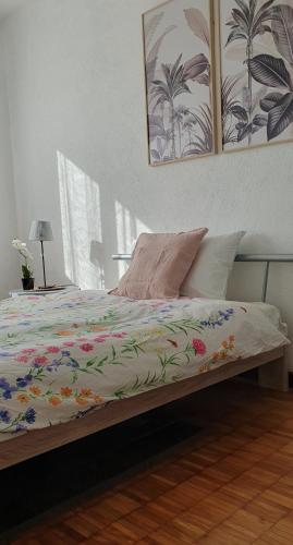 a bed with a colorful comforter on top of it at Charming Penthouse near Como lake in Chiasso