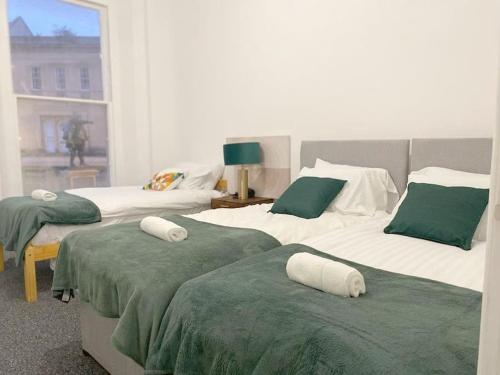 a bedroom with two beds with green and white sheets at Central Bridgewater Flat in Bridgwater