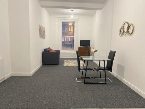 uma sala de estar com uma mesa e cadeiras e um sofá em Central Bridgewater Flat em Bridgwater