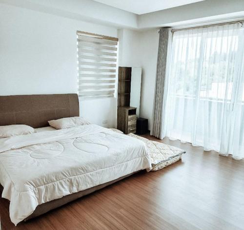 a bedroom with a bed and a large window at There's no place like home! By Mizu Homestay. in Miri