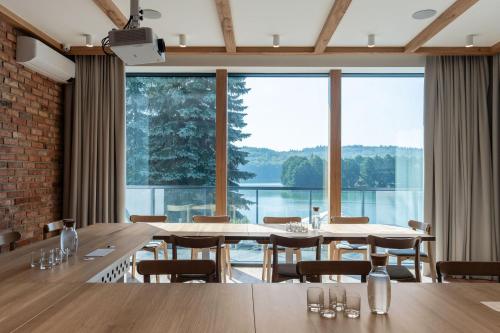 a dining room with tables and chairs and large windows at Tawerna Kaszubska in Ostrzyce